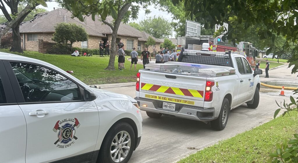 Photo of Garland Fire Department and Atmos on the scene investigating the possible cause of a house fire.
