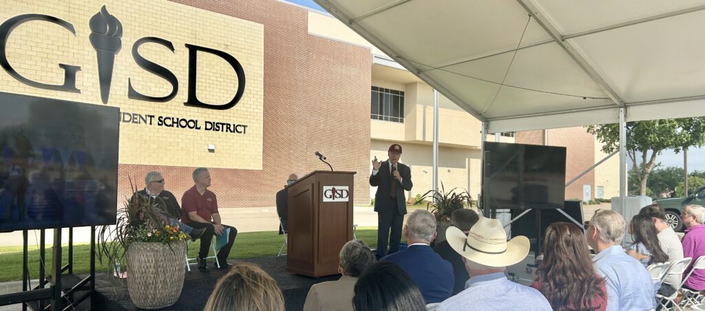 Larry H. Glick speaking in front of the Garland ISD Natatorium during the renaming ceremony honoring him.